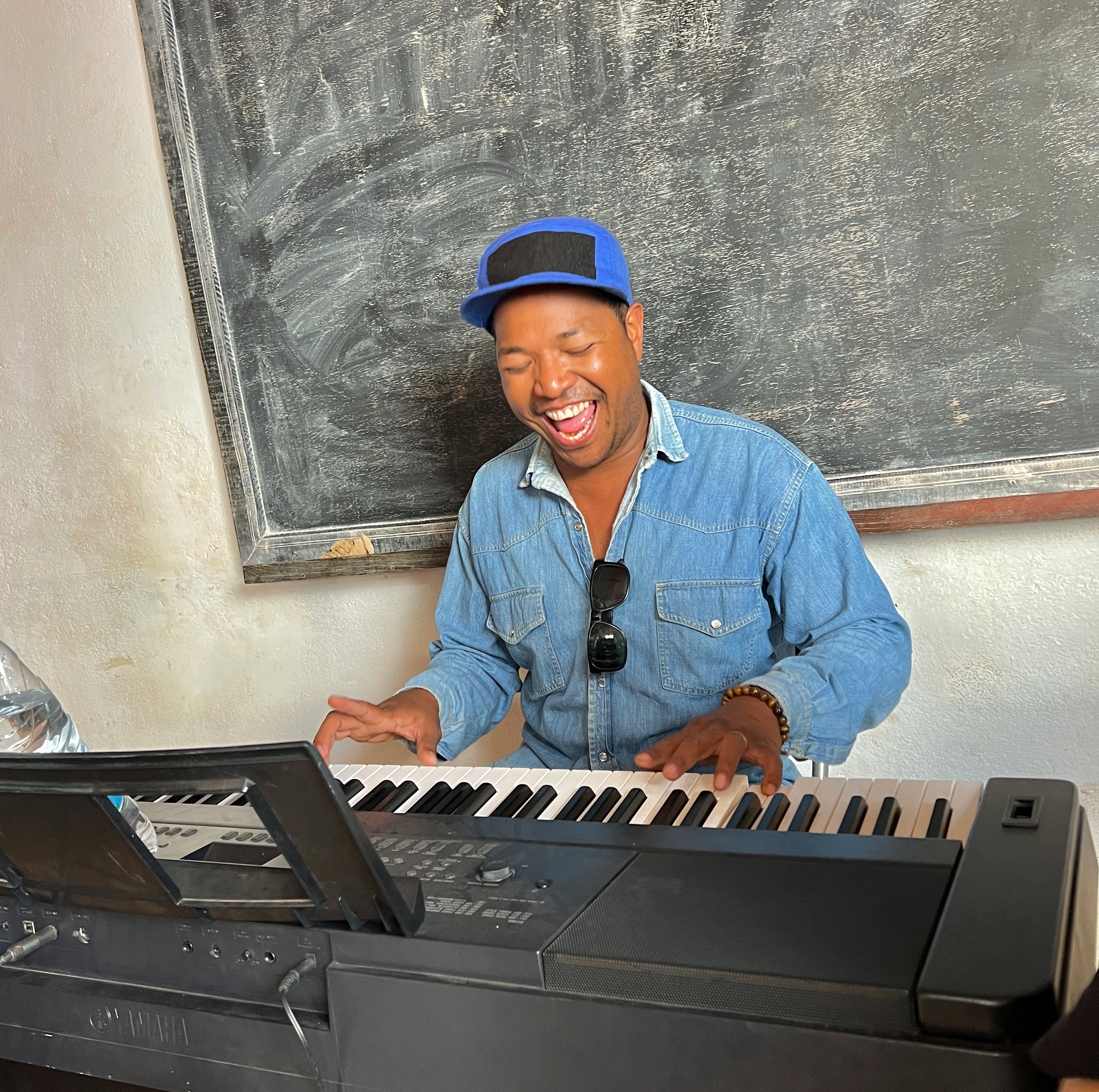 Man playing piano and smiling happily